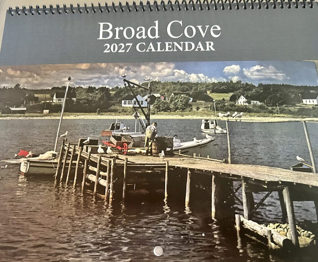 Cover of the Broad Cove 2027 Calendar: a wharf with gulls and a fisherman at work, houses along the far shore.